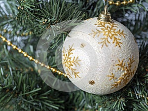 White ball with ornament hanging on a Christmas tree branch. Christmas and New Year concept