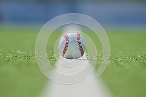 White ball for playing baseball on the grass background