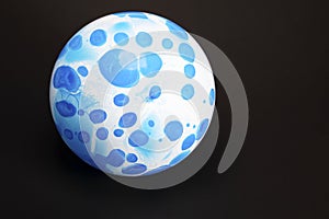 White balloon with blue polka dots on a black backround with text space