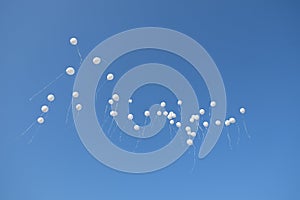 White balloons in the beautiful blue sky
