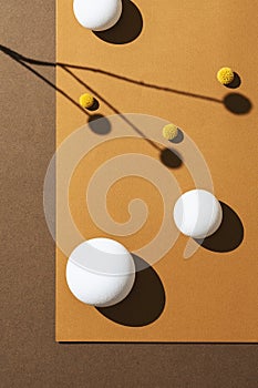 White balls, spheres on orange and brown background with high contrast sharp shadows