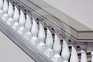 White balustrades with handrails of gray stone stairs.