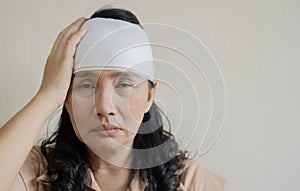 White bandage on Asian woman brain concussion wound head. Close-up