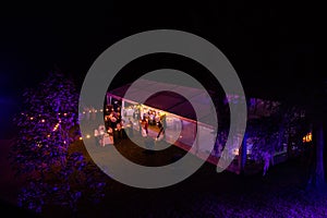 White banquet wedding tent at night with people