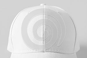 White baseball cap mockup on a grey background, closeup