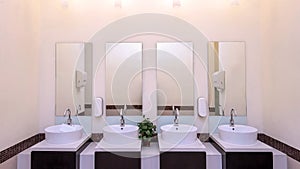 white basins in bathroom interior with granitic tiles