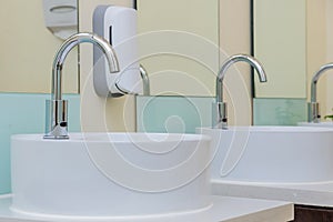 white basins in bathroom interior with granitic tiles