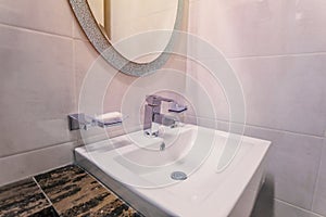 white basins in bathroom interior with granitic tiles