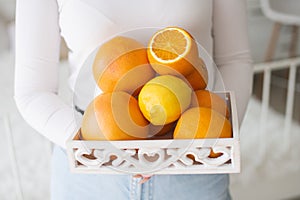 White basket with citrus fruits in hand