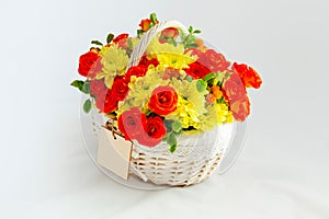 white basket with scarlet roses and yellow chrysanthemums. white background for cutting. card blank for the inscription