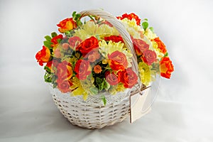 white basket with scarlet roses and yellow chrysanthemums. white background for cutting. card blank for the inscription