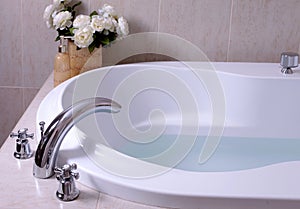 White bath tub with faucet and mozaic tiles