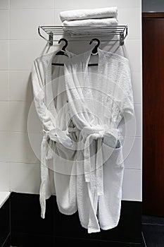 Fresh white bathrobes hanging