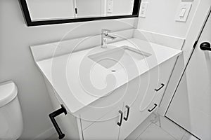 White bathroom sink with a black handle