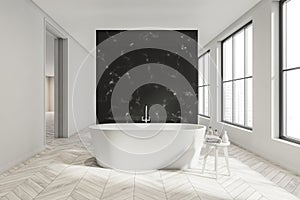 White bathroom space with black partition, walkways and ceramic bathtub