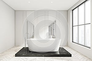 White bathroom space with black platform and ceramic bathtub