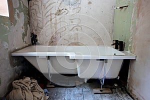 White bathtub with black taps being installed into bathroom