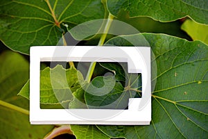 White battery icon on green leaves