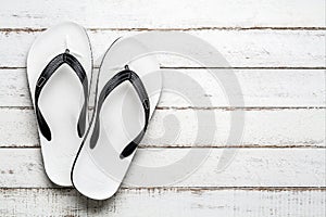 White Beach flip flop on a white wooden floor