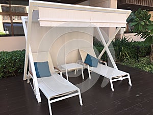 White Beach sunlounger at a deck near a pool. Sun Bed with a white cover