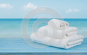 White beach towels on wood over blurred blue sea background