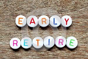 White bead with letter in word early retirement on wood background