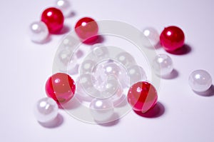 White beads. Beads are red. Separate beads. Placer beads. Beads are bigger and smaller. photo