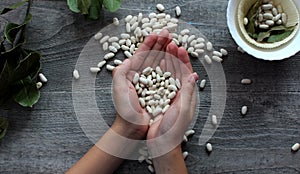 White beans and female hands symbolize healthy eating