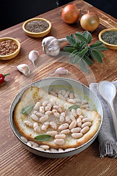 white beans soup with bread on kitchen table background