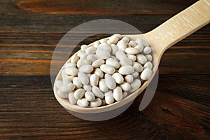White beans in a wooden spoon