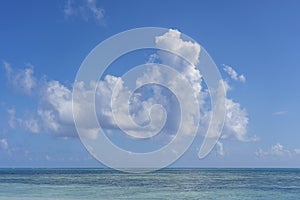 White beautiful clouds and blue sky over sea water waves on the island of Zanzibar, Tanzania, Africa. Travel and nature concept