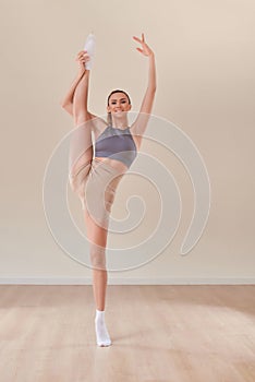 White beautiful european woman doing stretching. Gymnast. White studio background. Balance. Yoga pose. Sport