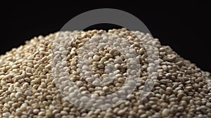 White beautiful quinoa strew on a black background. Quinoa is healthy and sport product for dishes.
