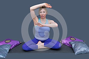 White beautiful woman is doing yoga exercises