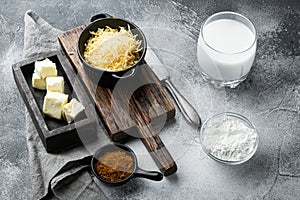 White Bechamel sauce ingredients, on gray stone background