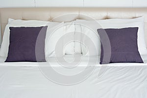 White bedding and grey pillow on the bed in hotel room