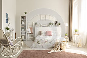 White bedroom interior with dirty pink carpet, rocking chair, wi