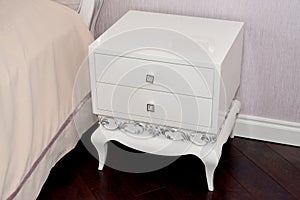 White bedside table in a bedroom