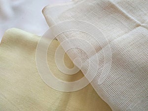 White, beige and yellow canvas close up. Bright fabric texture background