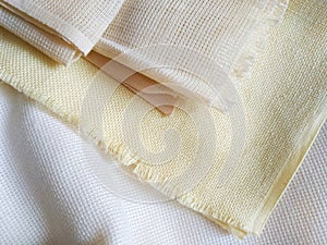 White, beige and yellow canvas close up. Bright fabric texture background