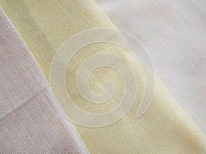 White, beige and yellow folded canvas. Bright fabric texture background