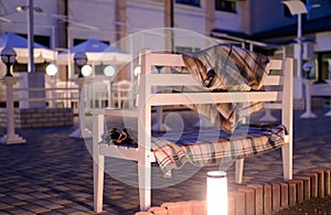 White Bench with Plaid Blankets on Patio at Dusk