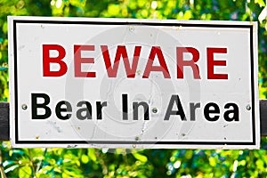 A white beware bear in area sign