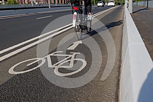 White bicycle icon symbol  and people ride bicycle on bicycle lane.