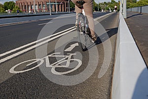 White bicycle icon symbol  and people ride bicycle on bicycle lane.