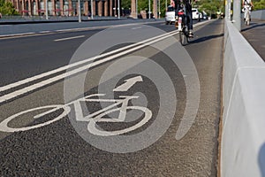 White bicycle icon symbol  and people ride bicycle on bicycle lane.