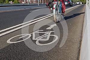 White bicycle icon symbol  and people ride bicycle on bicycle lane.