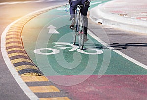 White bicycle lane sign and arrow on green asphalt road