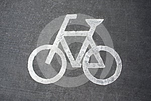 White bicycle sign on asphalt bike lane.