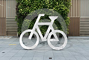 White bicycle sign on asphalt. Bike lane cycle on sidewalk.